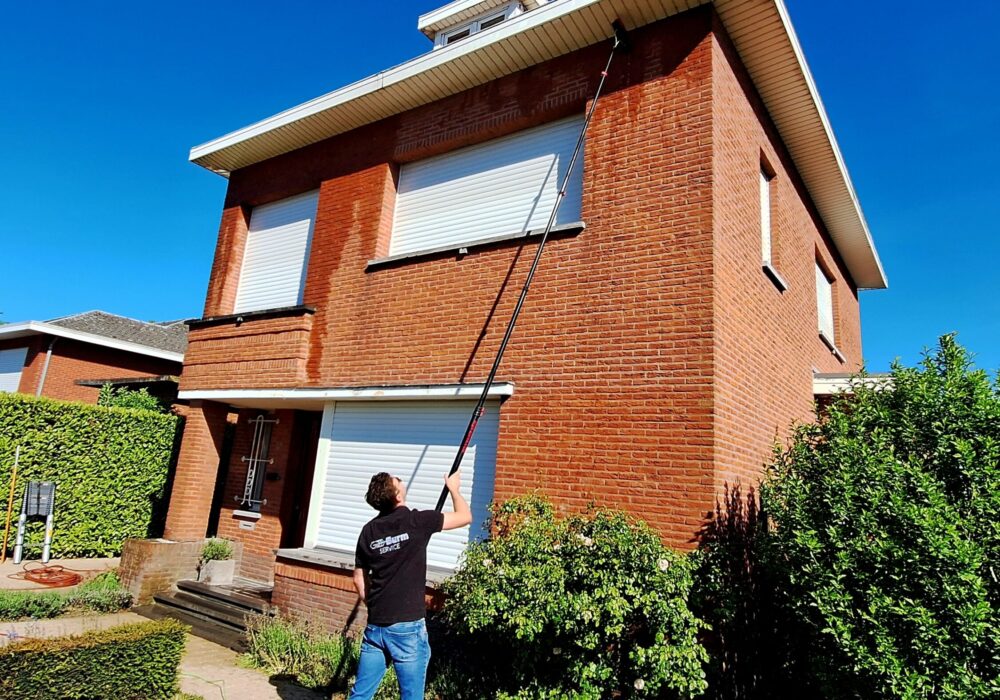 20250510_100520 Medewerker van Burm & Co maakt met een telescoopsteel de dakgoot van een woning schoon
