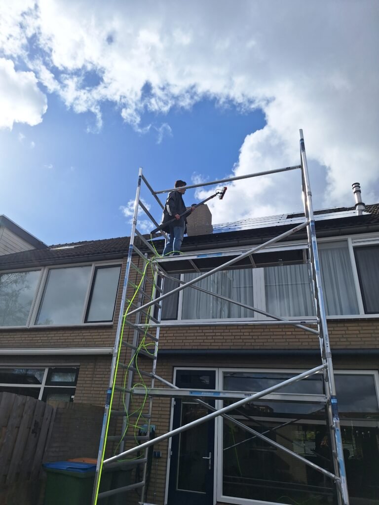 Zonnepanelen op een dak naast een dakkapel