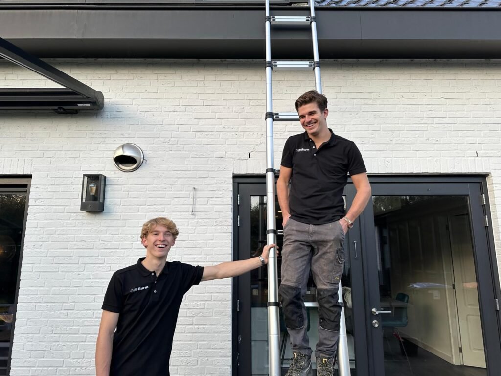 Boeidelen met groene aanslag onder de dakgoot van een woning