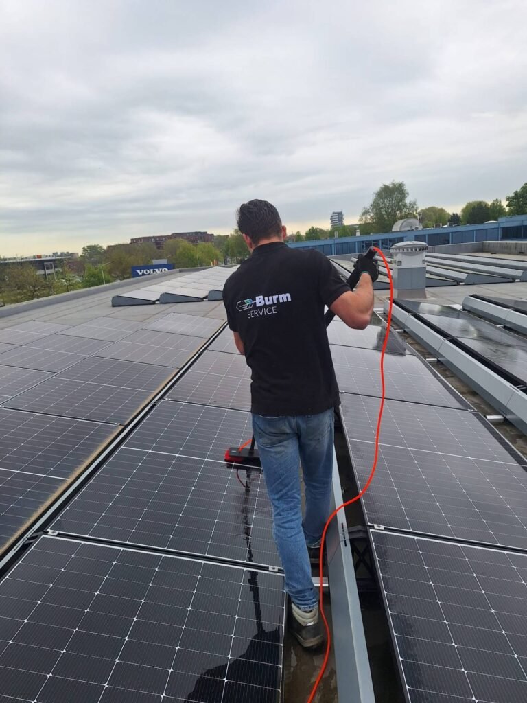 Zonnepanelen reinigen met een telescoopborstel op een plat dak door Burm & Co