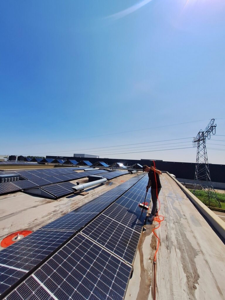 Zonnepanelen reinigen op een plat dak met een telescoopborstel