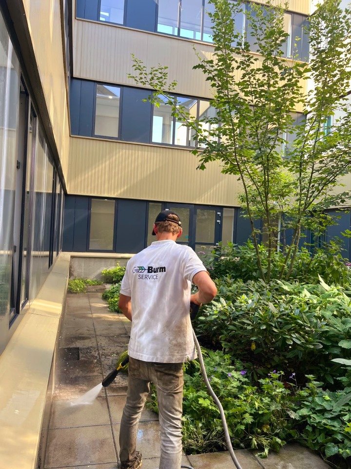 Bestrating reinigen in de binnentuin van een bedrijfspand door Burm & Co