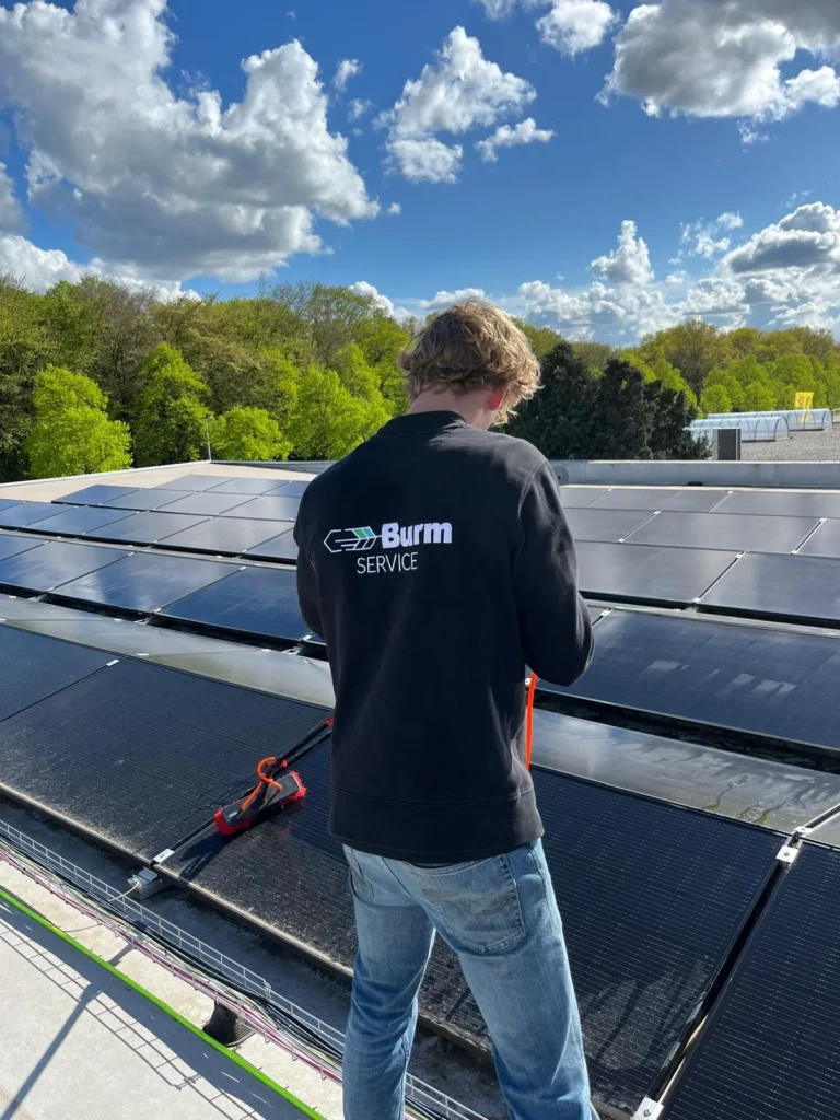 Burm & Co reinigt zonnepanelen op een plat dak met borstel en osmosewater